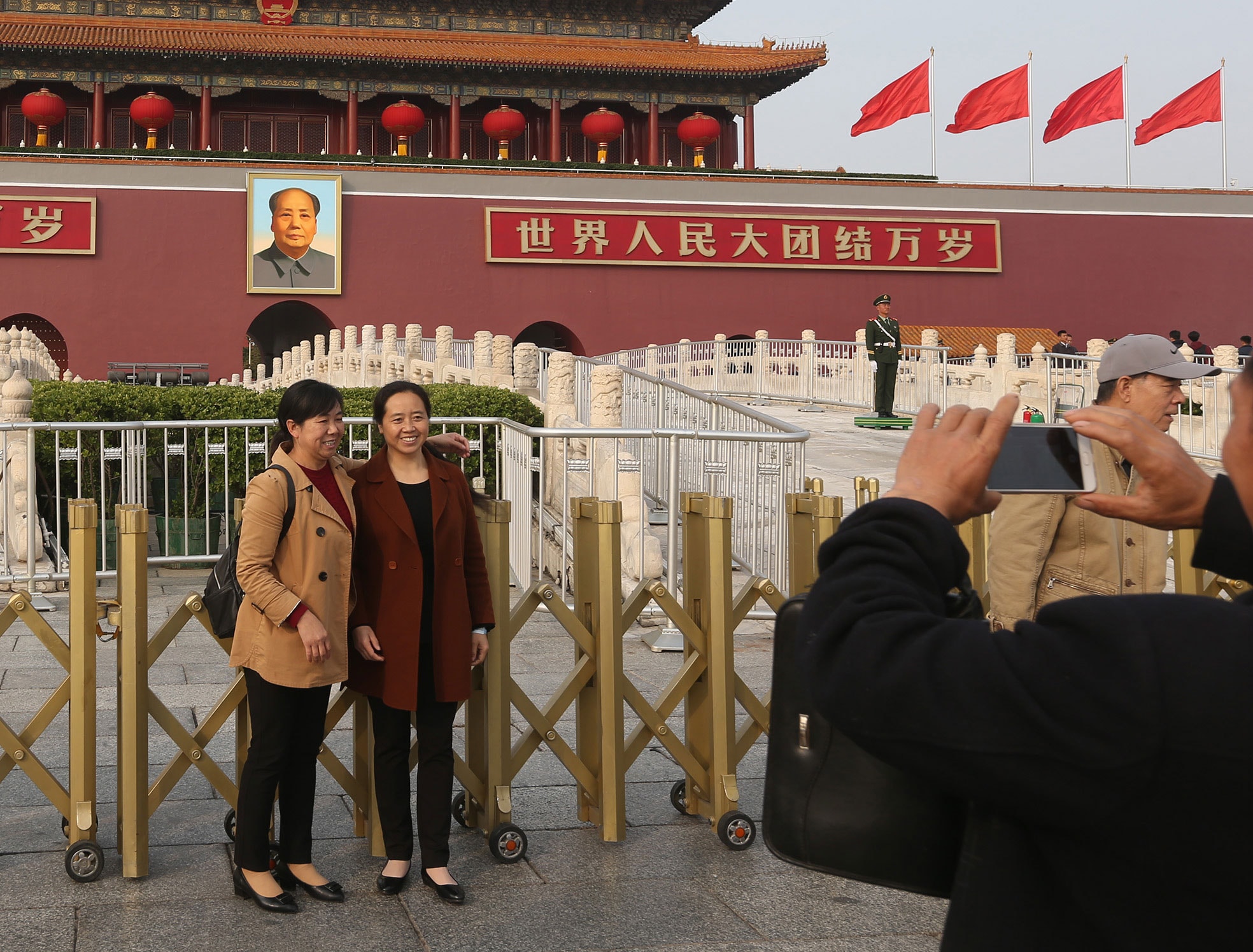 中共第19次全國代表大會（19大）即將在18日召開，北京市各項維穩管控措施升級，天安門廣場上民眾不受警戒氣氛影響，開心地在天安門外留下合照。