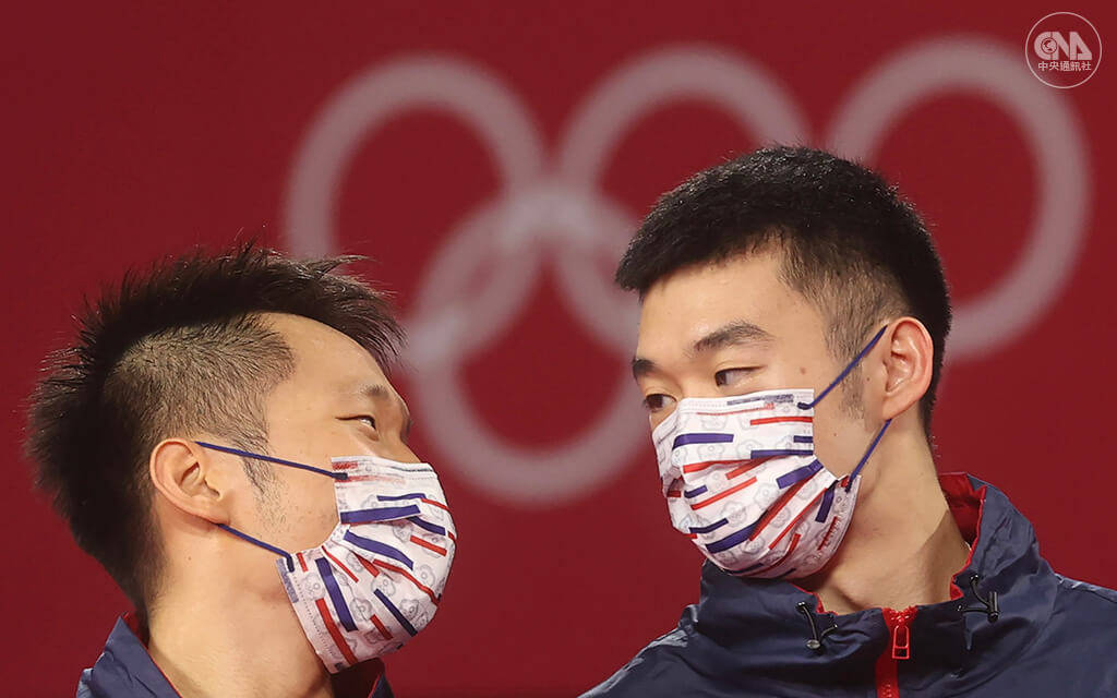 羽球男雙組合李洋(左起)、王齊麟擊敗中國選手,為台灣拿下東京奧運第2金,也成為台灣奧運羽球史上首面金牌。兩人一同登上頒獎台,頒獎前互相對望。