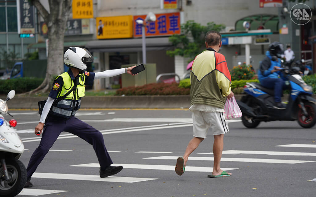全國5月19日起升級為三級警戒。一名員警在北市街頭巡邏時,攔檢勸導沒戴口罩的民眾。