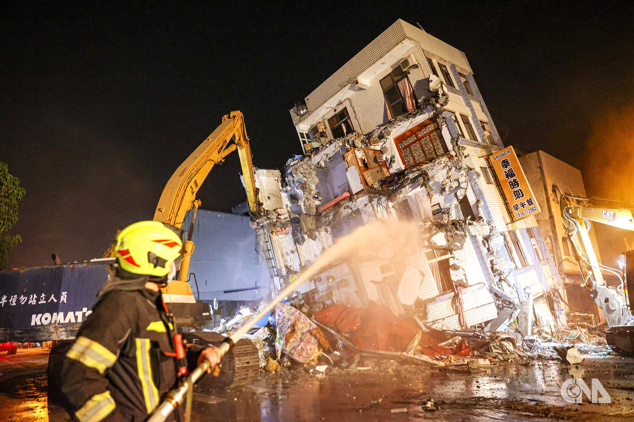 花蓮市北濱街與康樂街民宅因403地震嚴重傾斜,幸未造成傷亡,經過評估必須拆除,消防人員在現場灑水減少粉塵。