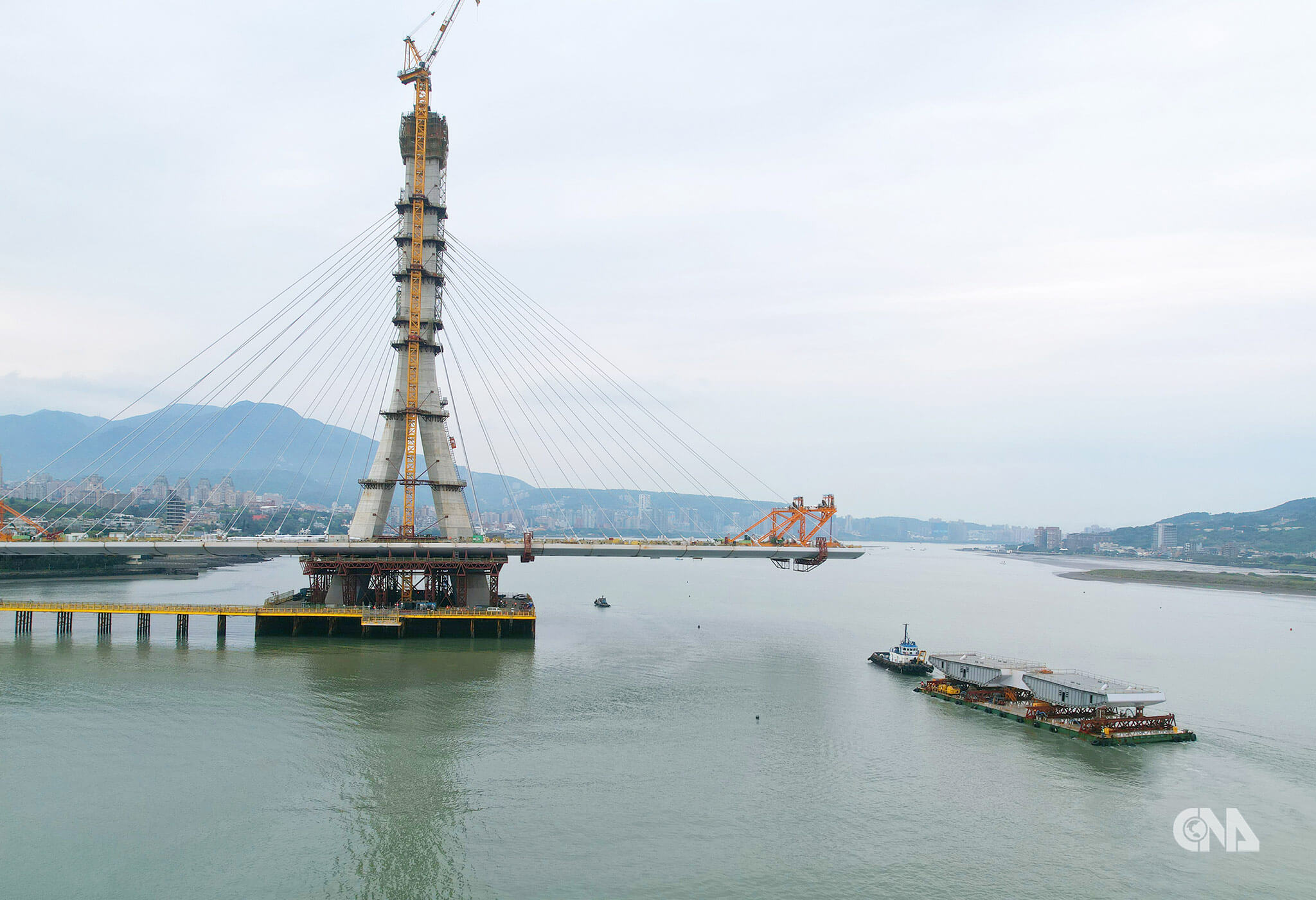 鋼梁節塊於台北港組裝後由拖板船運抵吊裝。