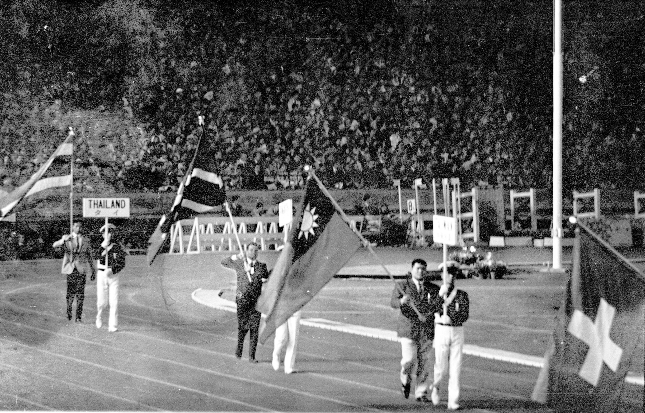 1964年東京奧運,中華民國以「台灣」(TAIWAN中華民國)的名義參加。圖為東奧閉幕典禮上,柔道選手張照輝(前右2)手持青天白日滿地紅國旗入場。(中央社檔案照片)